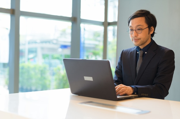 Retrato de um empresário japonês no escritório perto da janela