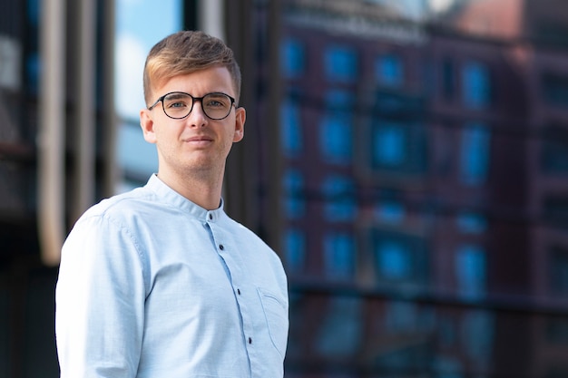 Retrato de um empresário masculino bonito com óculos, olhando diretamente para a câmera