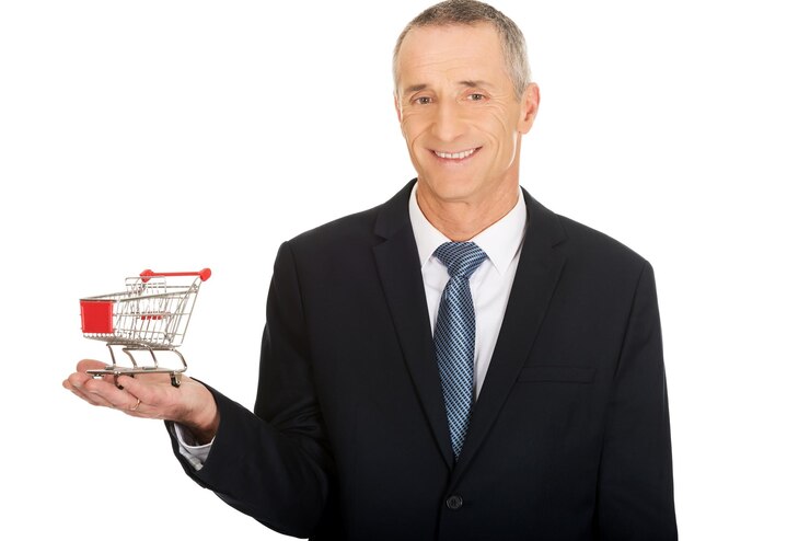 Foto retrato de um empresário segurando um carrinho de compras enquanto está de pé contra um fundo branco