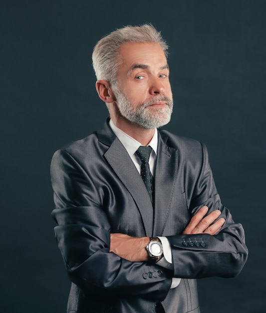 Retrato de um empresário sênior. Isolado em fundo escuro.