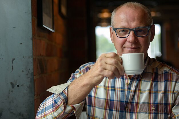 Retrato de um empresário sênior tomando café na cafeteria