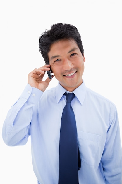 Retrato de um empresário sorridente fazendo um telefonema