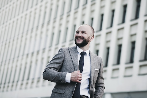 Retrato de um empresário sorridente. Homem feliz posando na paisagem urbana.