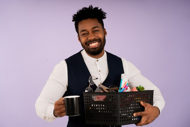 Retrato de um empresário sorrindo enquanto segura uma caixa com itens pessoais para o escritório. conceito de negócios.