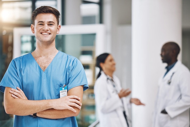 Retrato de um enfermeiro com sua equipe em segundo plano no hospital Enfermeira sorridente e confiante feliz com médicos em medicina saúde e cuidados médicos Equipe médica de saúde e enfermagem