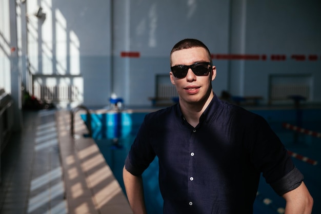 Retrato de um esportista nadador profissional na piscina de camisa branca