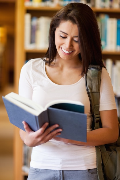 Retrato de um estudante bonito lendo um livro