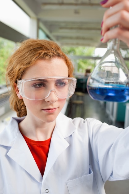 Retrato de um estudante de ciências olhando um frasco