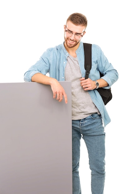 Retrato de um estudante do sexo masculino sorridente segurando o estudante universitário de oportunidades de educação em placa em branco