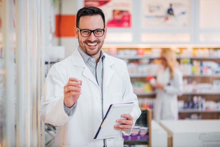 Retrato de um farmacêutico considerável com prancheta, sorrindo na câmera.