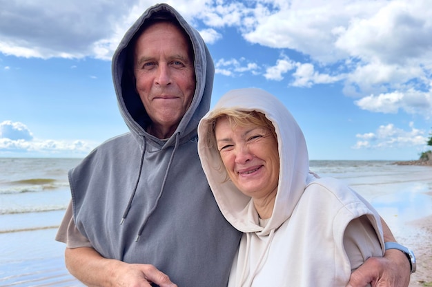 Retrato de um feliz casal de idosos apaixonados andando em uma praia no sorriso de verão rindo, divirta-se