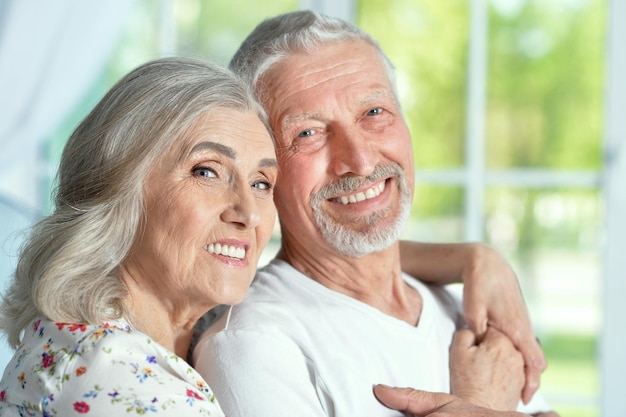 Retrato de um feliz casal sênior posando em casa