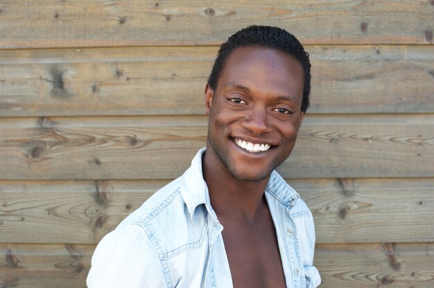 Retrato, de, um, feliz, homem jovem, sorrindo, ao ar livre