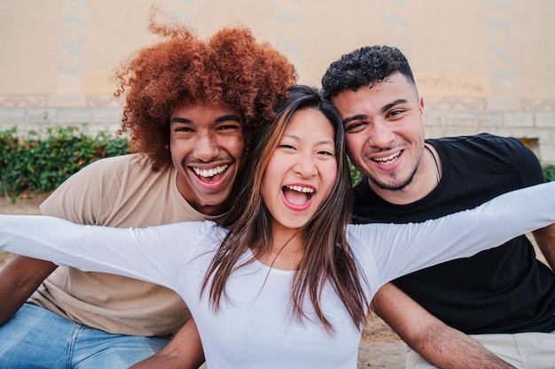 Foto retrato de um grupo de adolescentes multirraciais rindo e sorrindo juntos uma jovem asiática