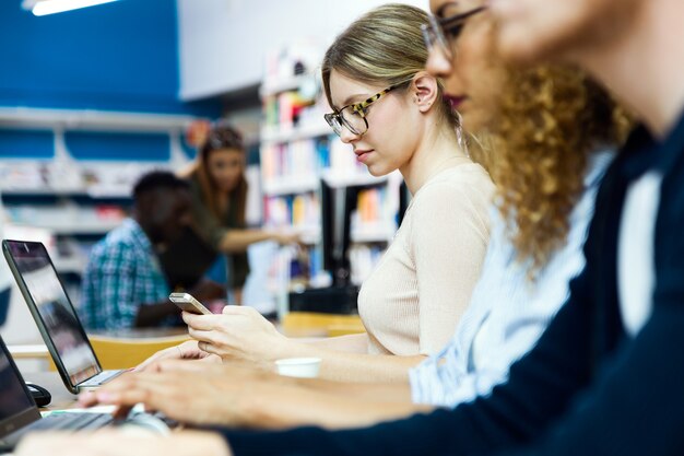 Retrato de um grupo de amigos estudando na biblioteca de uma universidade.