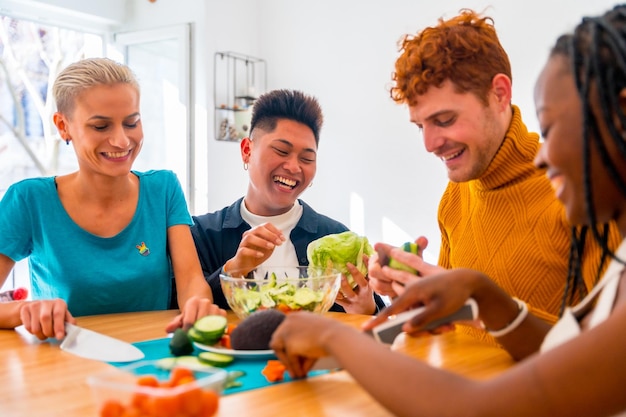 Retrato de um grupo de amigos preparando comida vegetariana Preparando a salada e se divertindo em casa