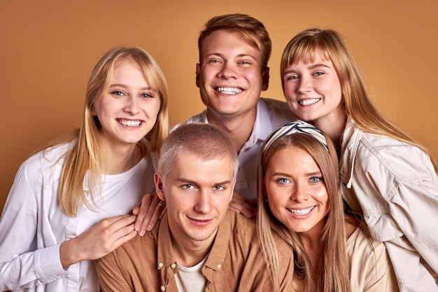 retrato de um grupo feliz e sorridente de jovens posando juntos