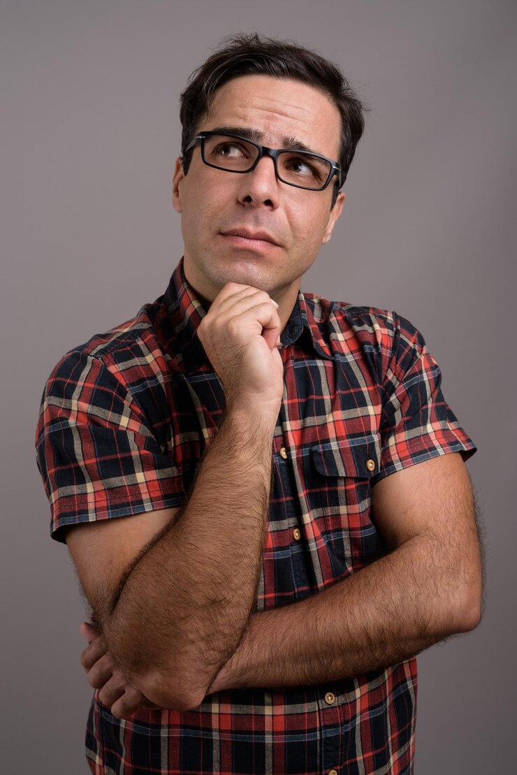 Foto retrato de um homem adulto em pé contra um fundo cinzento