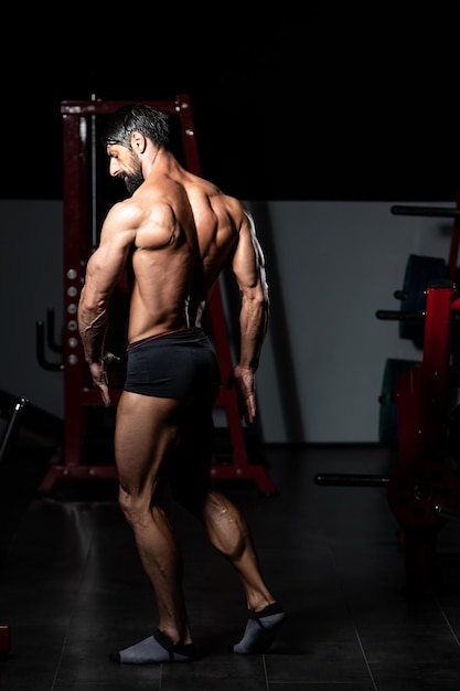 Retrato de um homem adulto fisicamente apto mostrando seu corpo bem treinado - Muscular Atlético Bodybuilder Fitness modelo posando após exercícios