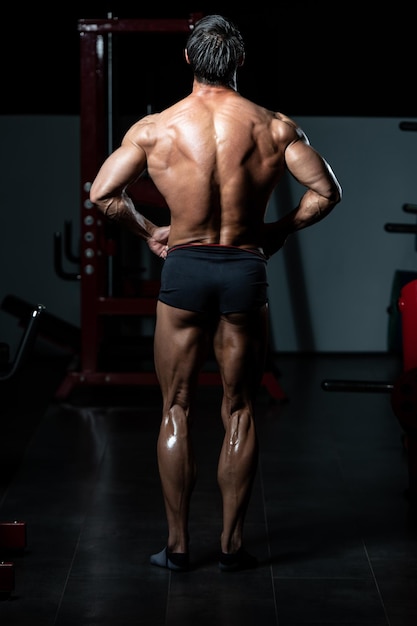 Retrato de um homem adulto fisicamente apto mostrando seu corpo bem treinado - Muscular Atlético Bodybuilder Fitness modelo posando após exercícios