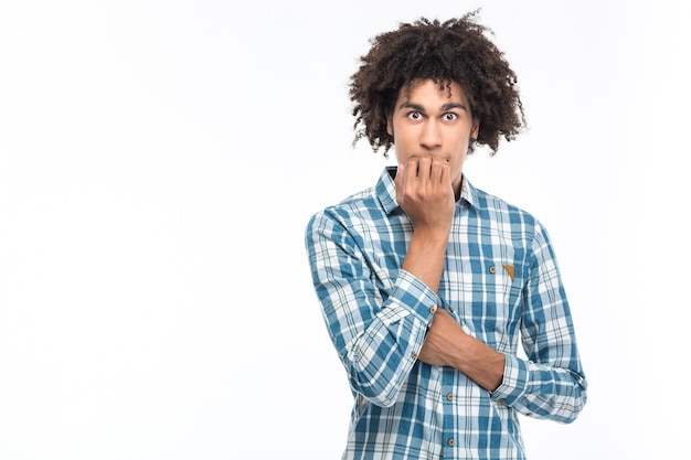 Retrato de um homem afro-americano assustado com cabelo encaracolado isolado em uma parede branca