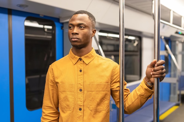 Retrato de um homem afro-americano em uma camisa amarela brilhante que anda em transporte público