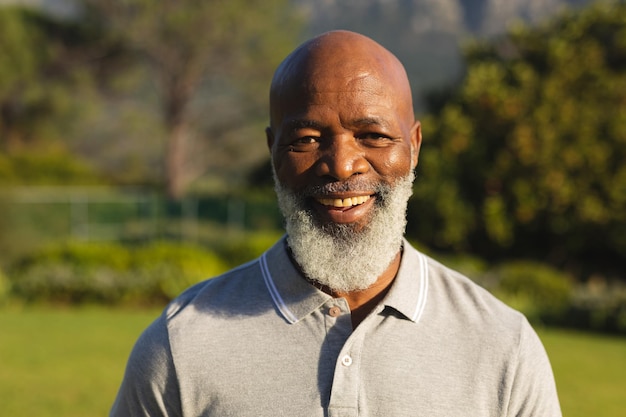 Retrato de um homem afro-americano sênior sorridente em uma paisagem deslumbrante. aposentadoria e conceito de estilo de vida sênior ativo.