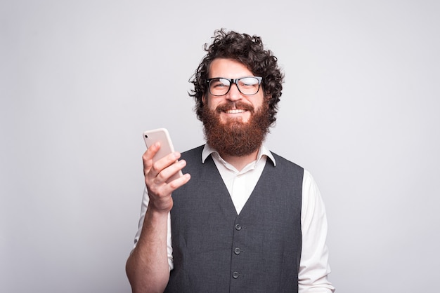 Retrato de um homem alegre com barba, usando óculos e olhando confiante para a câmera.