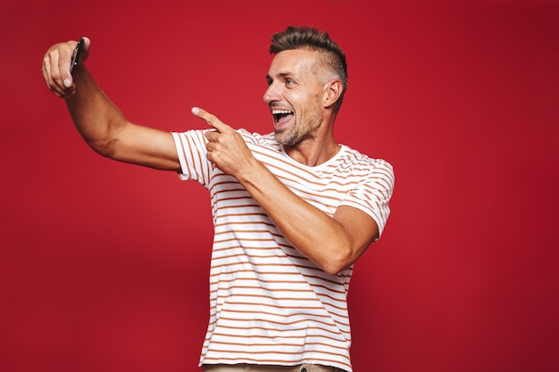 Retrato de um homem alegre parado no vermelho