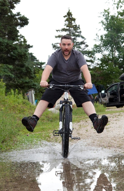 Foto retrato de um homem andando de bicicleta na chuva