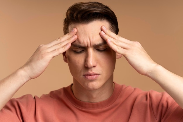 Retrato de um homem ansioso preocupado tocando a cabeça sentindo dor sofrendo problemas de enxaqueca