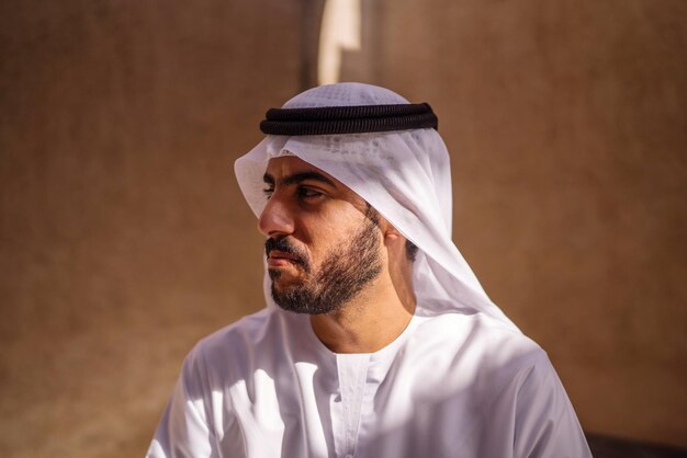 Retrato de um homem árabe vestindo dishdash kandura de pé no distrito histórico