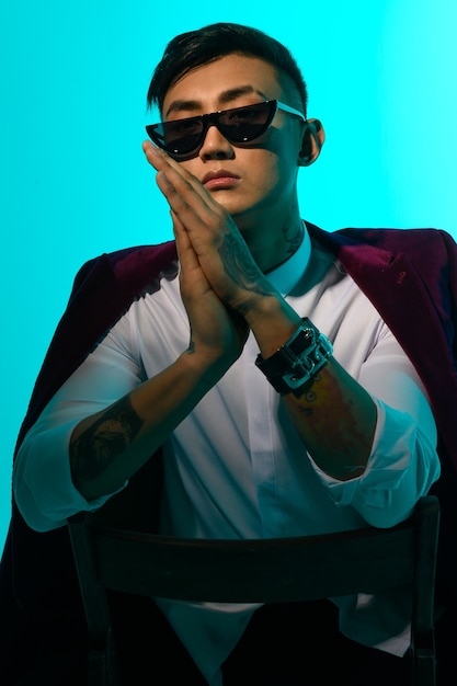 Retrato de um homem asiático elegante com óculos e jaqueta.