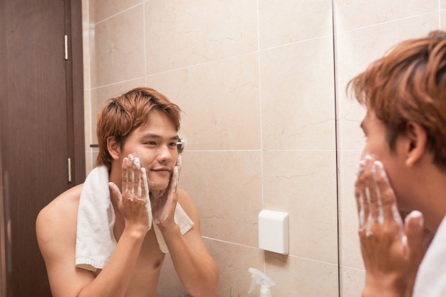 Retrato de um homem asiático lavando no banheiro