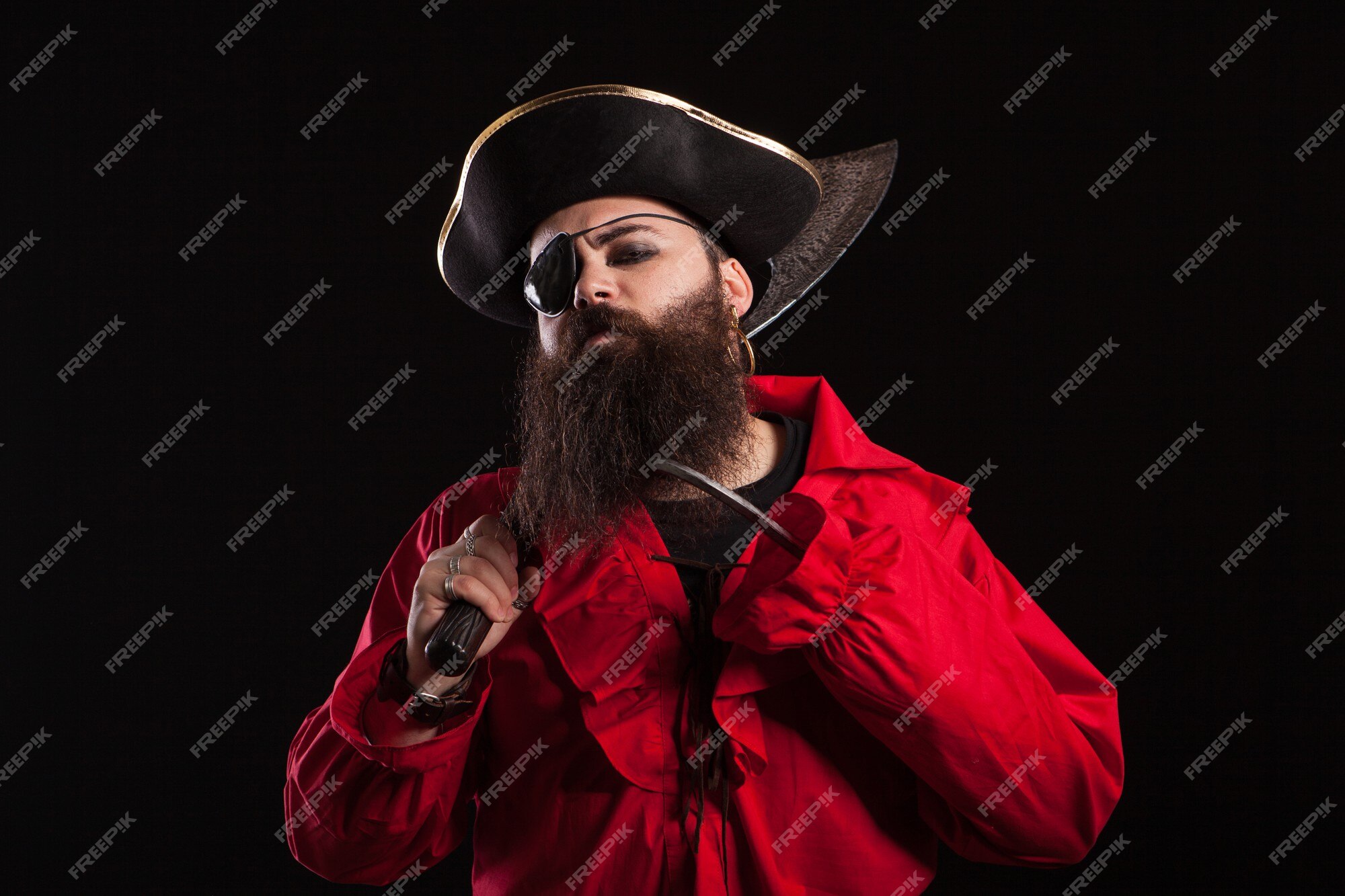 Ator em uma fantasia de pirata e um chapéu de capitão para o halloween.  homem barbudo bonito vestido como um pirata do caribe para o carnaval.