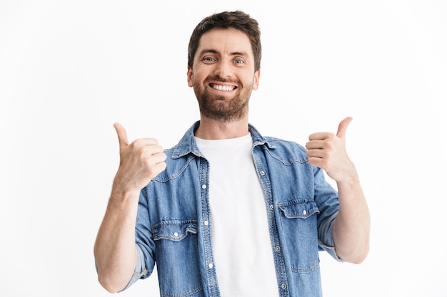 Retrato de um homem barbudo bonito feliz, vestindo roupas casuais, isolado, mostrando os polegares para cima