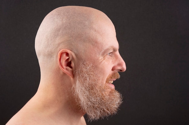 Retrato de um homem barbudo e careca de perfil