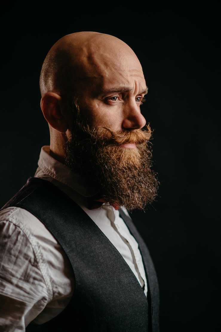 Foto retrato de um homem barbudo elegante adulto em um fundo preto