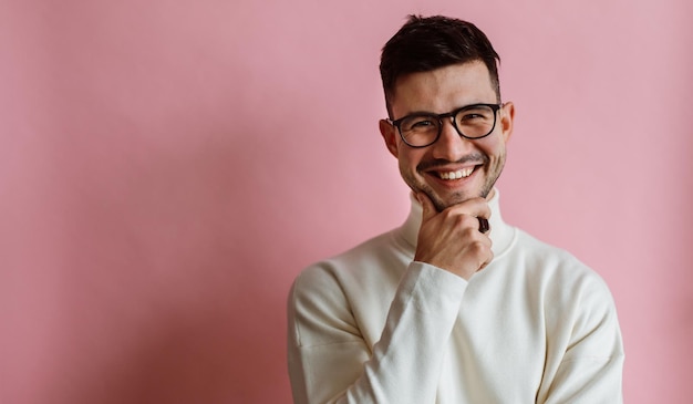 Retrato de um homem barbudo feliz usando óculos rindo e olhando a câmera enquanto posava isolado