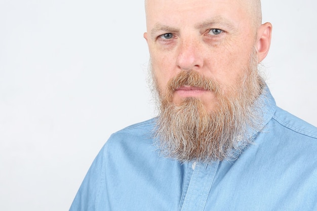 Retrato de um homem barbudo sério com uma camisa azul