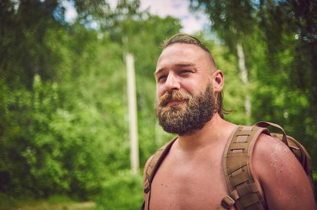 Foto retrato de um homem barbudo turista com uma mochila.