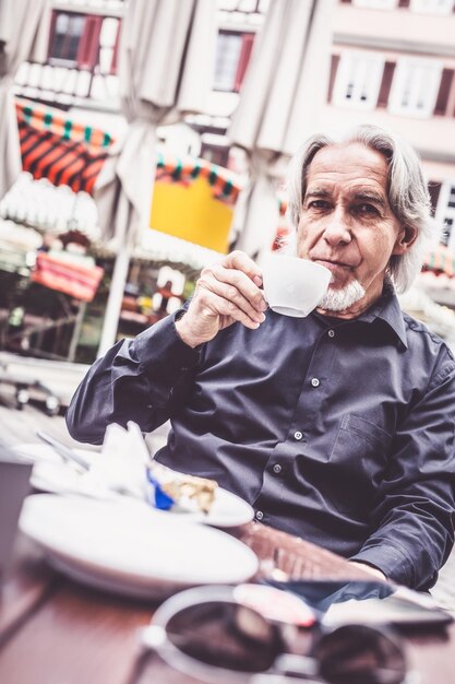 Foto retrato de um homem bebendo café em um café na calçada