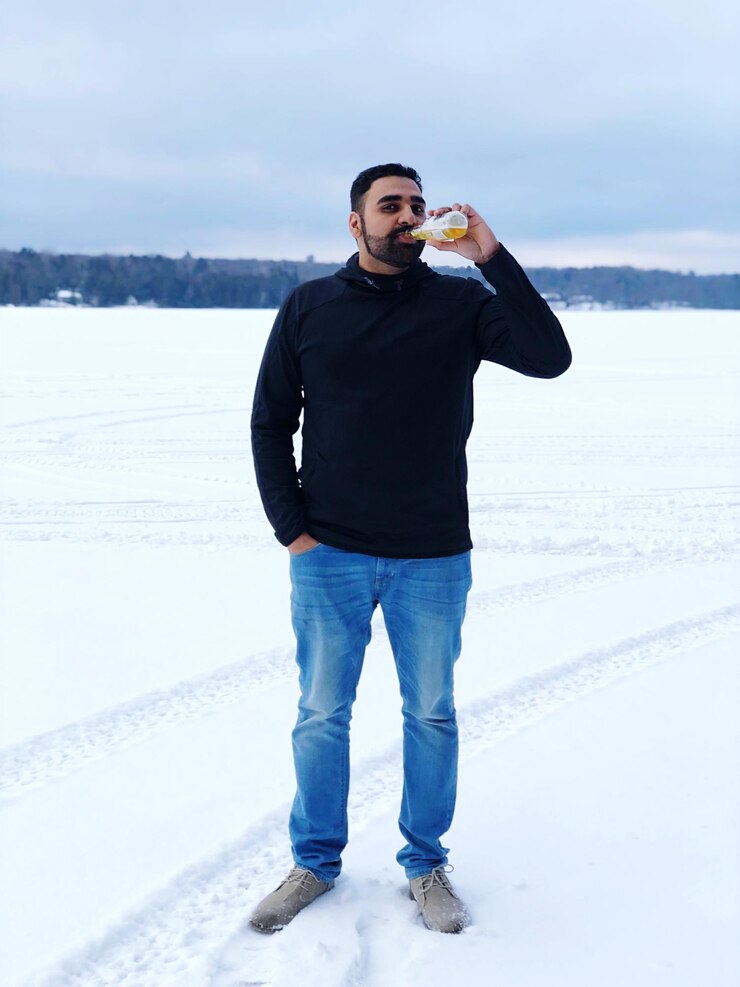 Foto retrato de um homem bebendo em um campo coberto de neve