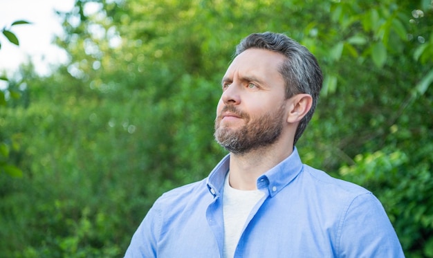 Retrato de um homem bonito com barba, olhando de lado o espaço de cópia de fundo natural