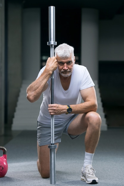 Foto retrato de um homem bonito de cabelos grisalhos e uma camiseta branca. conceito de esporte e saúde.