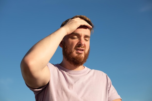 Retrato de um homem bonito, doente e exausto, cansado, que sofre de sol quente de verão