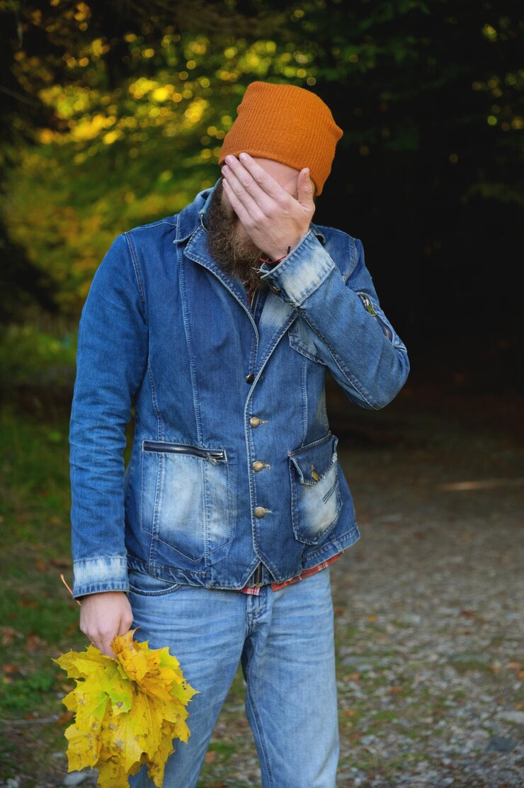 Foto retrato de um homem bonito em roupas casuais de pé no parque contra o fundo de