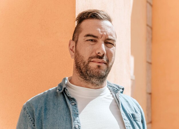 Retrato de um homem bonito hipster em uma jaqueta jeans Um homem em uma cidade grande na rua um estilo de vida
