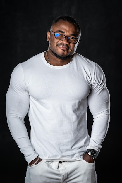 Retrato de um homem bonito modelo afro americana fitness. O fisiculturista totalmente branco mostra um corpo forte.