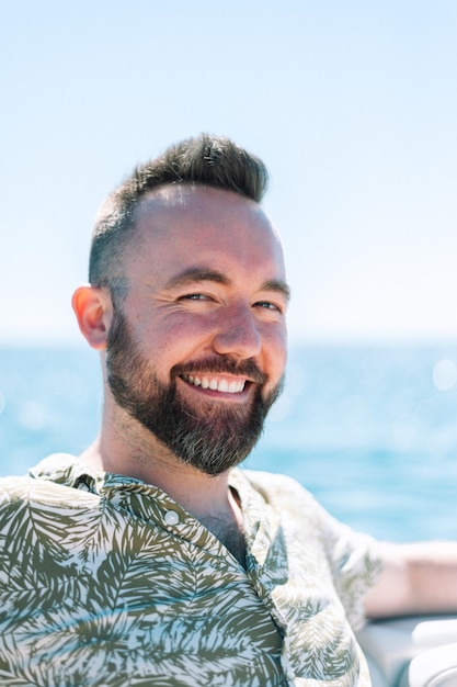 Retrato de um homem bonito sorrindo em um barco no mar Mediterrâneo